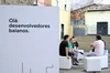 Participantes do Innovators Hive, em Salvador, interagindo com engenheiros de nuvem do Google Cloud, do lado de uma placa que diz "Olá, desenvolvedores baianos".