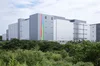 The exterior of Google’s data center, a wide gray building with grass and trees in the forefront.