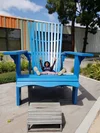 Patrice sitting in an oversized chair outdoors.