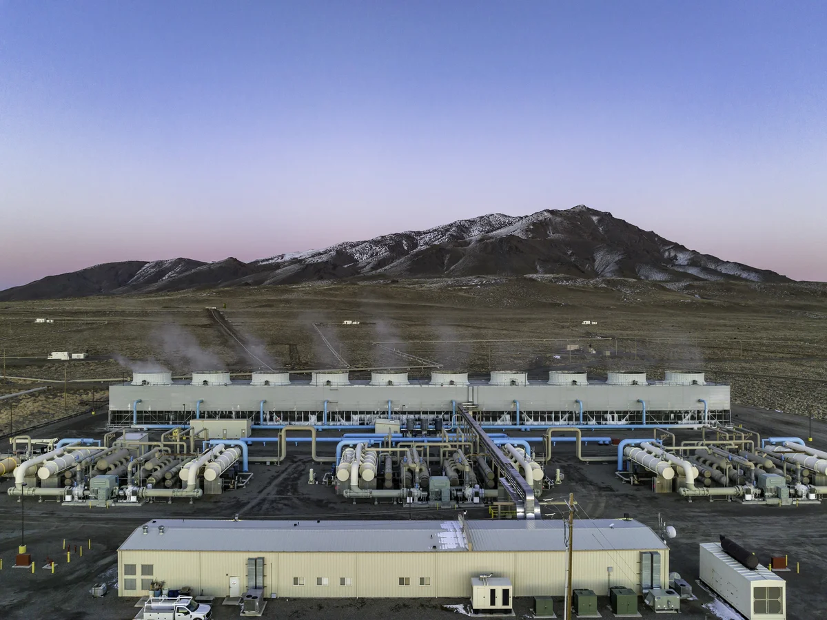 Industrial facility generating clean energy with mountains in the background
