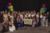 The 2022 State Teachers of the Year hold up an image of the Teacher Appreciation Week Doodle and the Google logo, with yellow, red, green and blue balloons in the background.