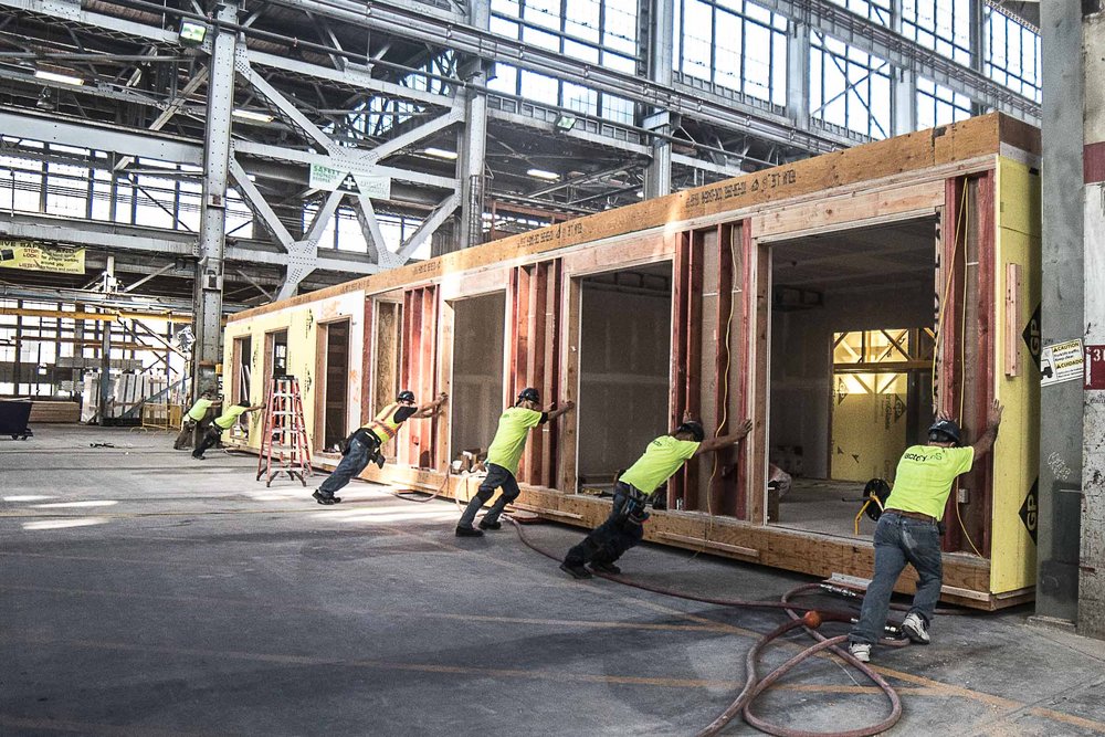 Workers are manufacturing a modular home.