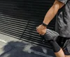 A runner in dark clothing stretching his legs before a run with a black Fitbit Charge 6 on his wrist