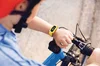 A person on a bike looks at their Ace 3 Special Edition: Minions device on their wrist