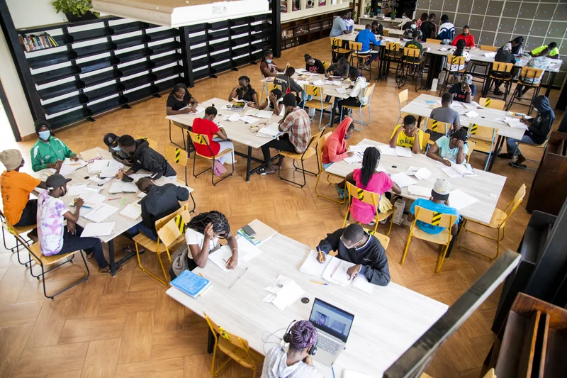 Photo from above of people seated at different tables, studying in a library renovated by Book Bunk.