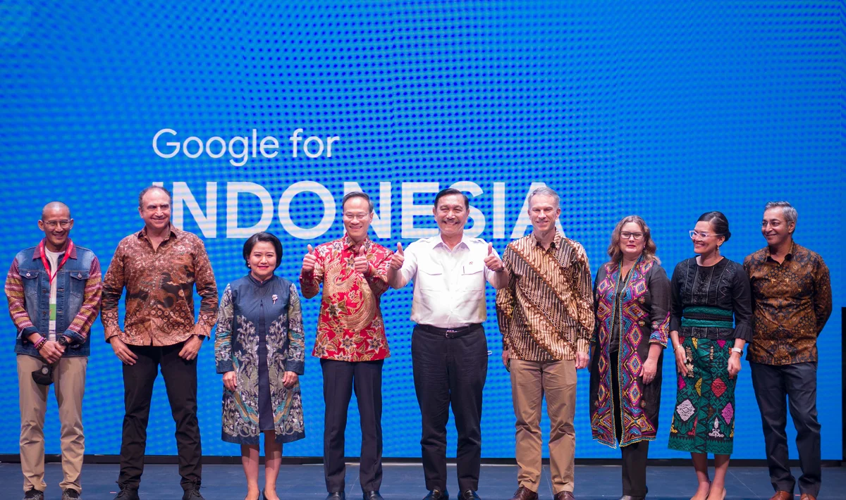 Nine people standing on a stage and smiling. The wall behind them reads "Google for INDONESIA"