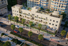 Image of the exterior of a tall building on a tree-lined city street