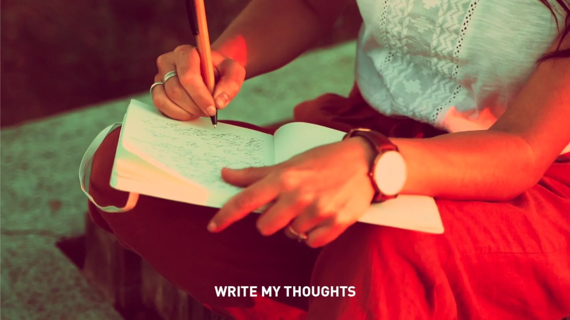 Image showing a woman writing in a notebook, which is a still from a video by Egyptian artist Ghada Wali titled Red Cairo Rides where she takes viewers on a trip into Cairo and all  its complexities and contradictions, through a red lens.