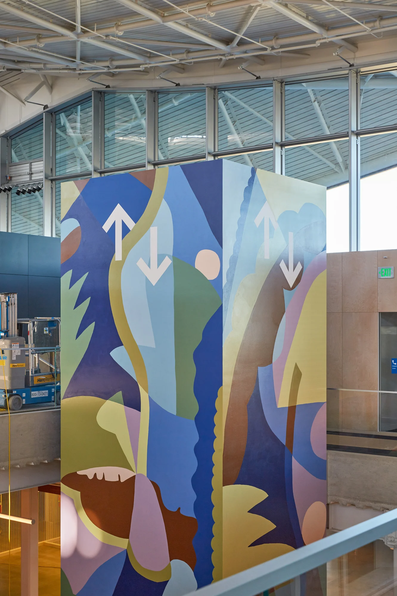 A photograph of Rachel's mural on an elevator. Various abstract shapes primarily in blue and green shades suggest water and grasses.