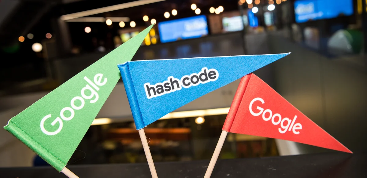 Image showing three small flags, the first is green and says "Google," the second is blue and says "hash code" and the third is red and says "Google."