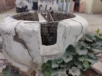 A stone well, looking worn and cracked.