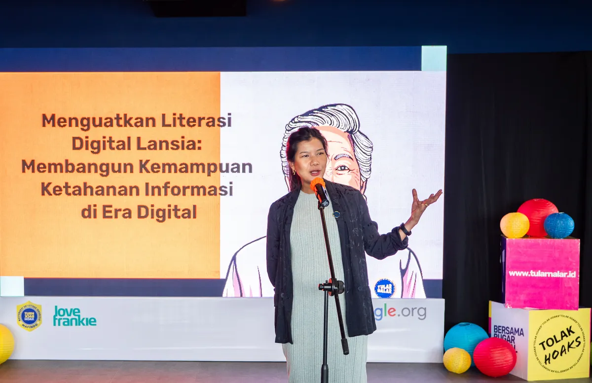 Foto seorang perwakilan Google Indonesia memberikan pidato di depan backdrop