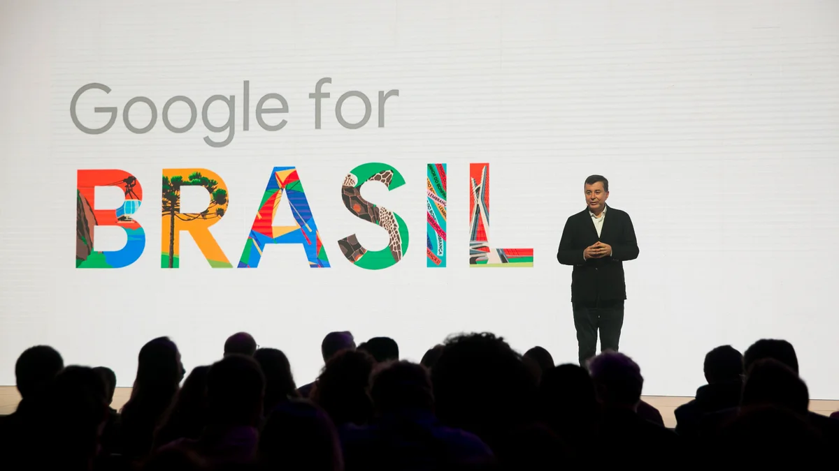 Fabio stands on stage in front of a live audience and a screen that says “Google for Brazil”