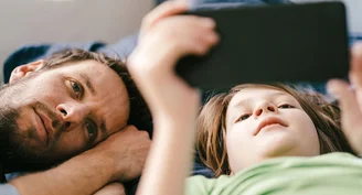 An image of a father and son looking at a phone screen