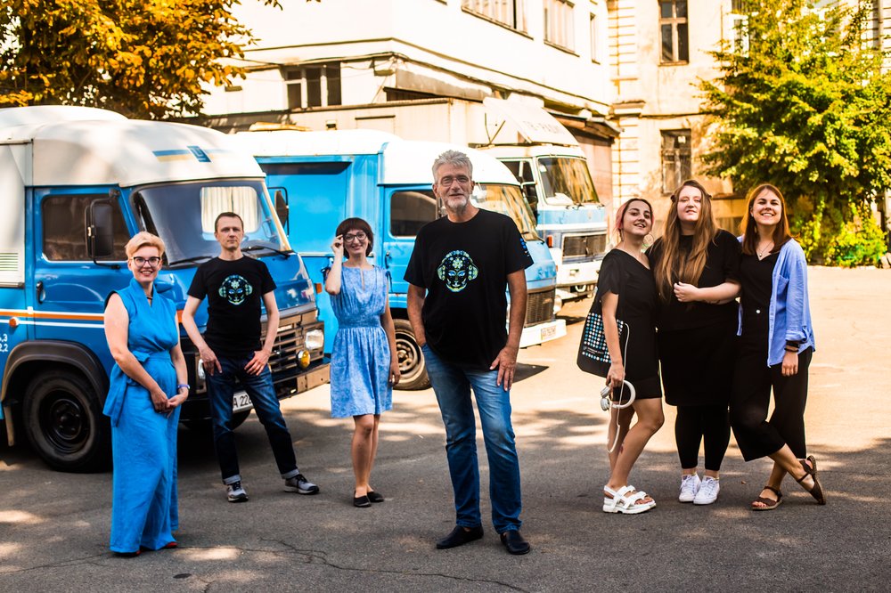 Photo of seven members of the team from Hromadske Radio standing outside in front of vehicles.