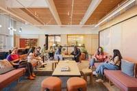 A photo of the interior of The Huddle with people congregated and talking on couches.