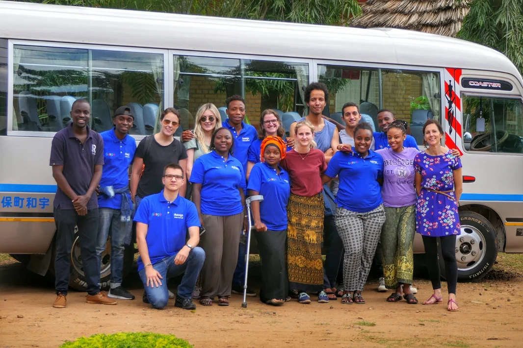 Robert Lehmann mit anderen Volunteers vor einem Bus stehend in Tansania