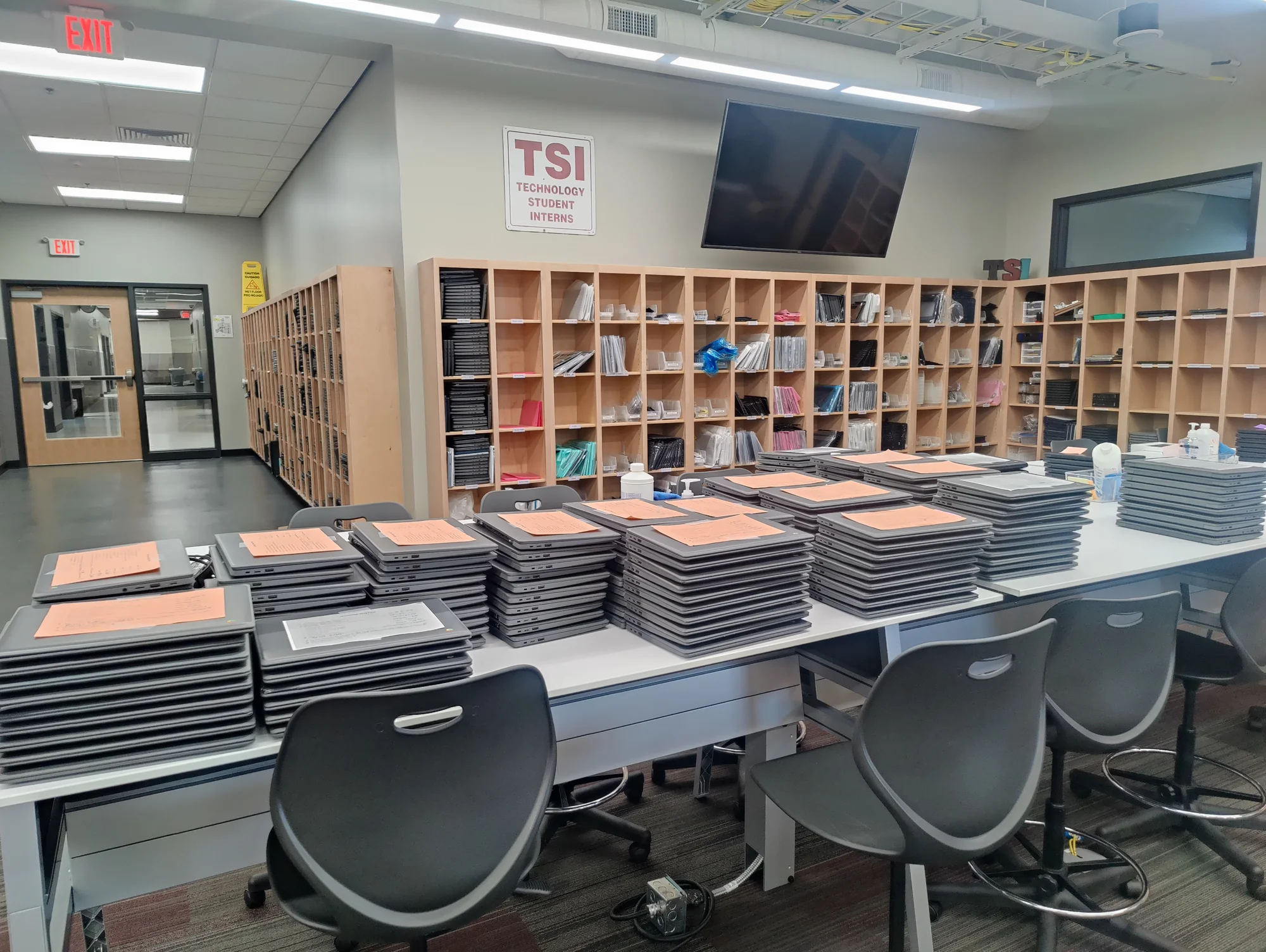 Stacks of Chromebooks on a table awaiting repair