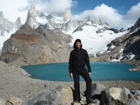 Bilal Essafi steht im sonnigen Patagonien vor einem See. Im Hintergrund ein Bergpanorama.