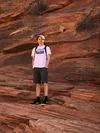 Aidan poses for a photograph while standing on a rocky structure.