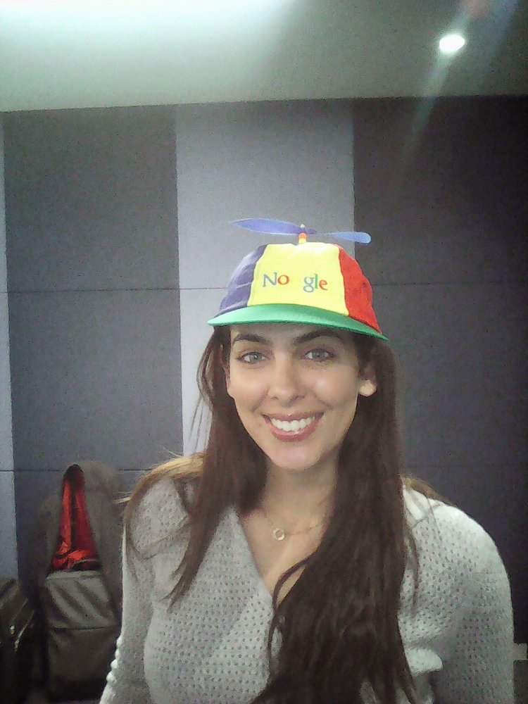 Dina in a Noogler hat indoors.