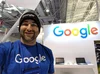 Jesus at a Google career fair booth wearing a google hat and beanie.