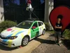 Frances standing in front of a large statue of the maps icon next to a street view car.