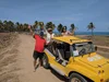 Gabriella (rechts) mit ihren Eltern am Strand und einem gelben Jeep