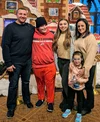 Joelle and her family in front of a gingerbread house.