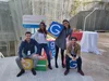 Four people sitting on and holding boxes painted with the Google letters and colors.