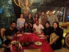 Ten people gathered around a table inside of a restaurant.