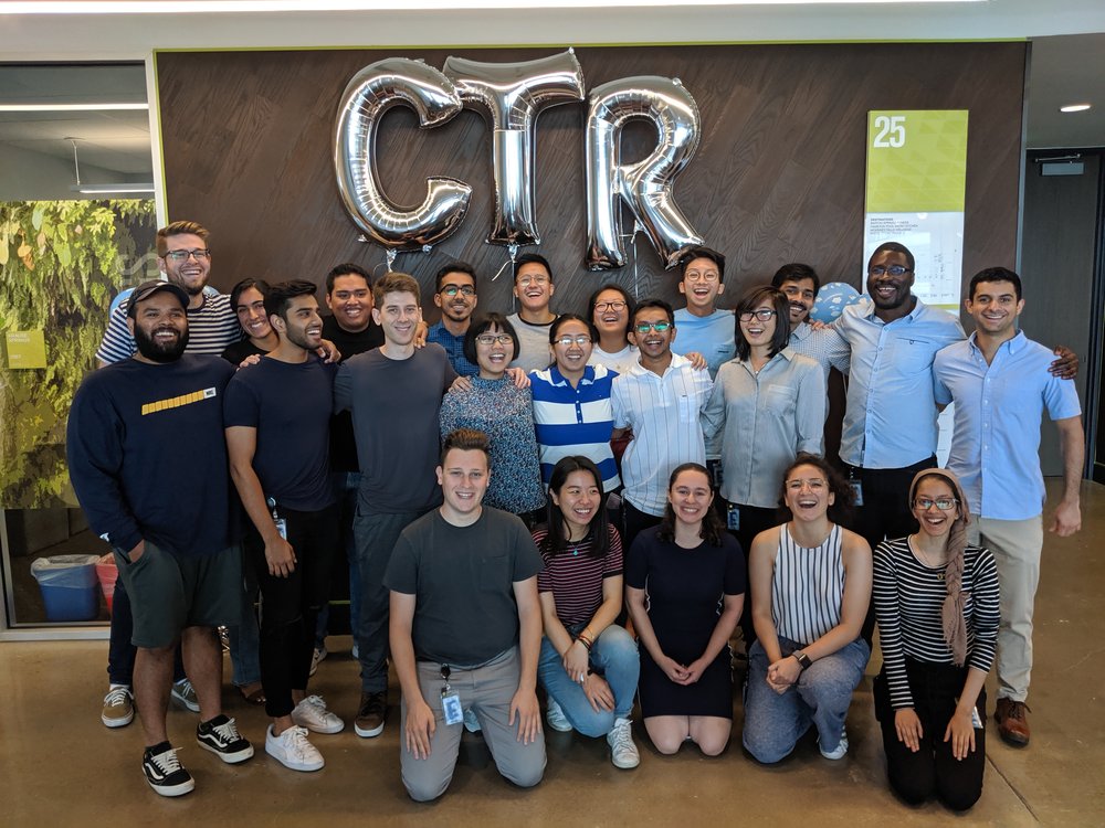 Group of individuals in front of large balloons letters reading "CTR".