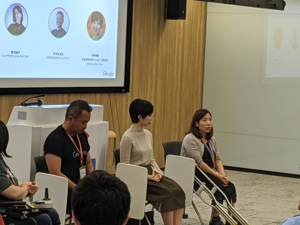 The image shows three Google employees sitting in a conference room facing an audience. One Googler is sharing her personal experiences as a person with a disability in Japan.