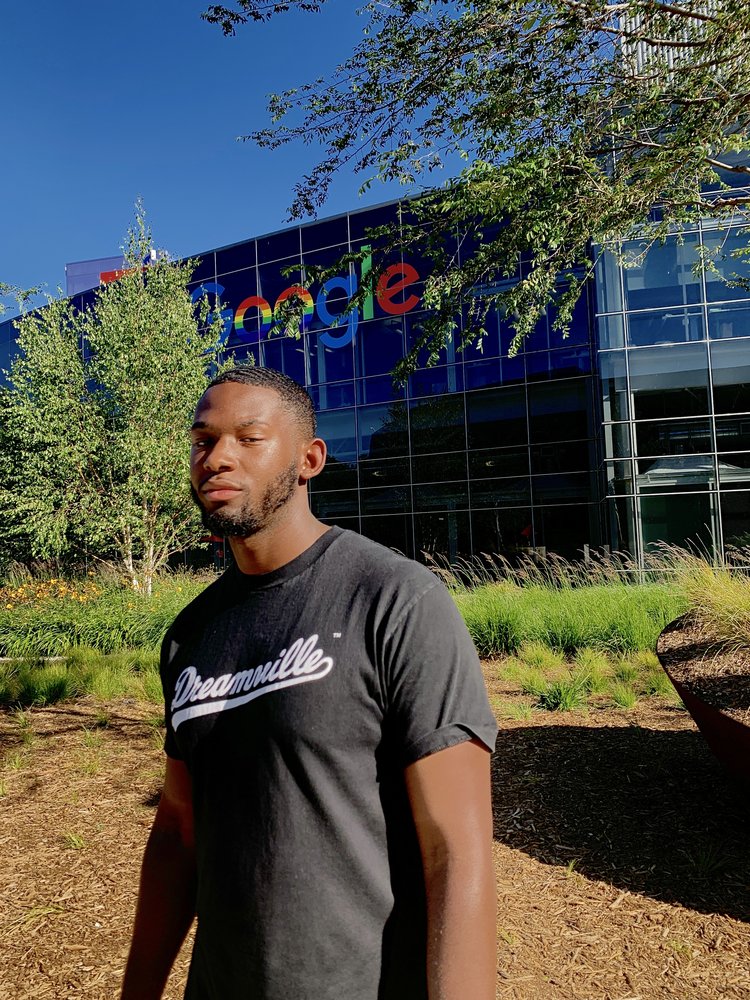 Grant, in a black t-shirt, posing in front of the Google logo outside our Mountain View headquarters.