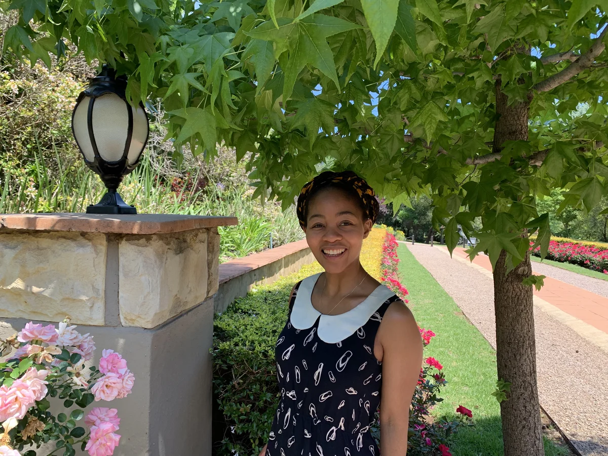 A picture of Lerato against a backdrop of a tree and road