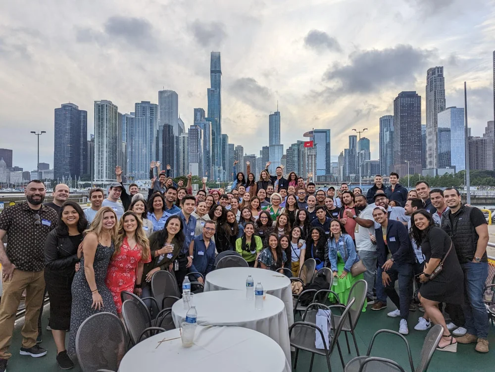 A large group of people poses together in front of a city skyline.
