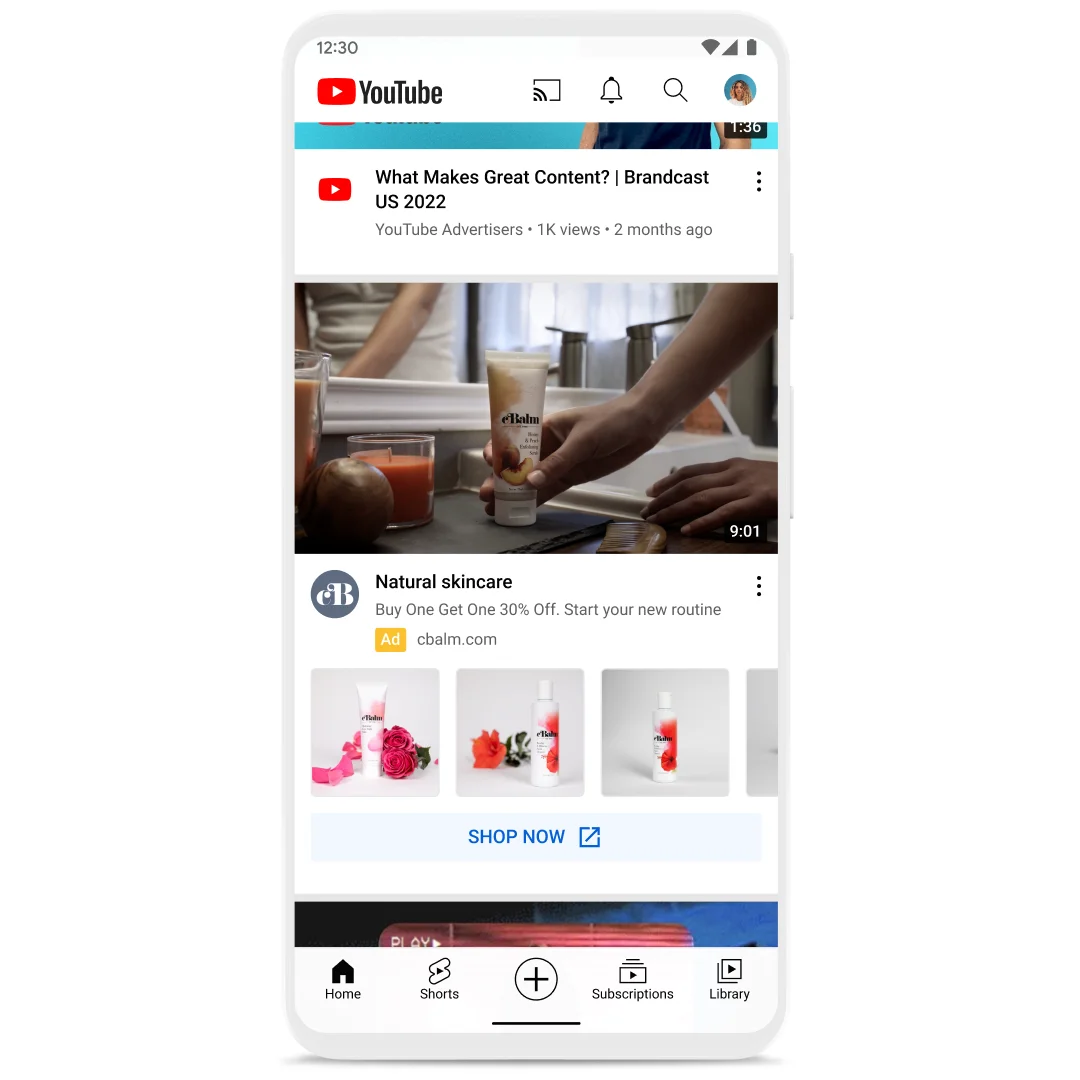 Still image of mobile phone on YouTube in-feed video content with an ad shown for skincare. Images of different skincare products are shown below the ad with a prominent “Shop now” button.
