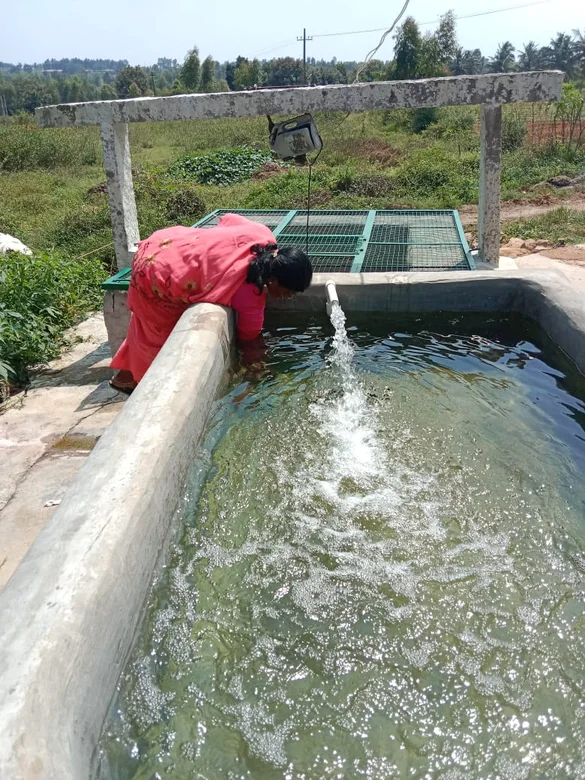 A woman takes water from a well.