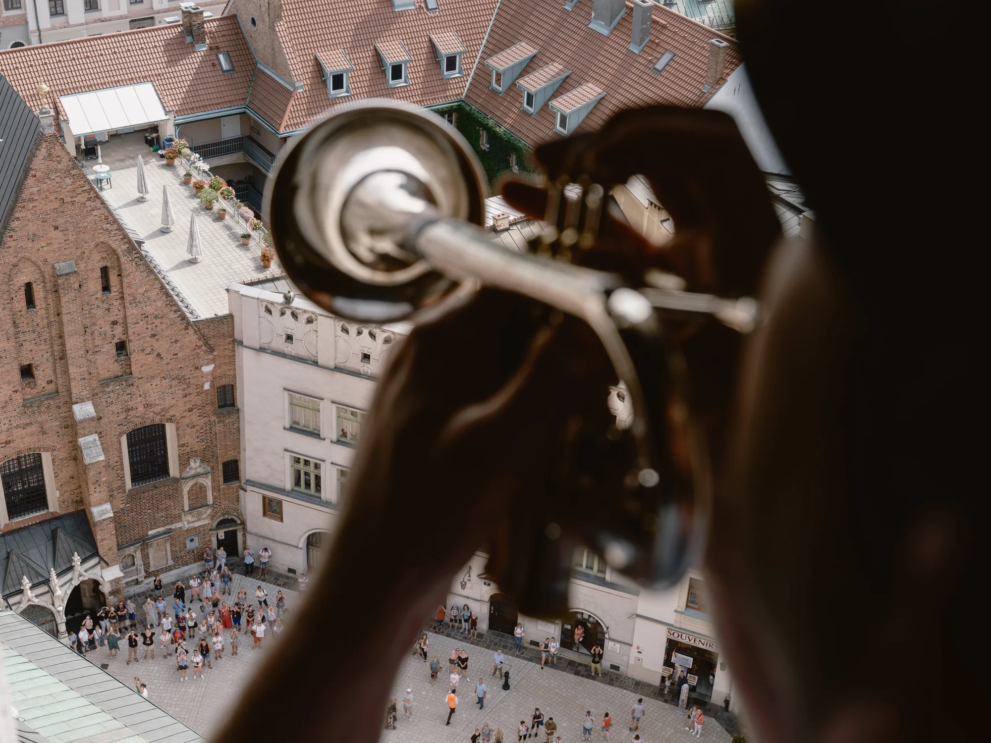 Photo of a man playing trumpet call at the tower of St Mary's Church.