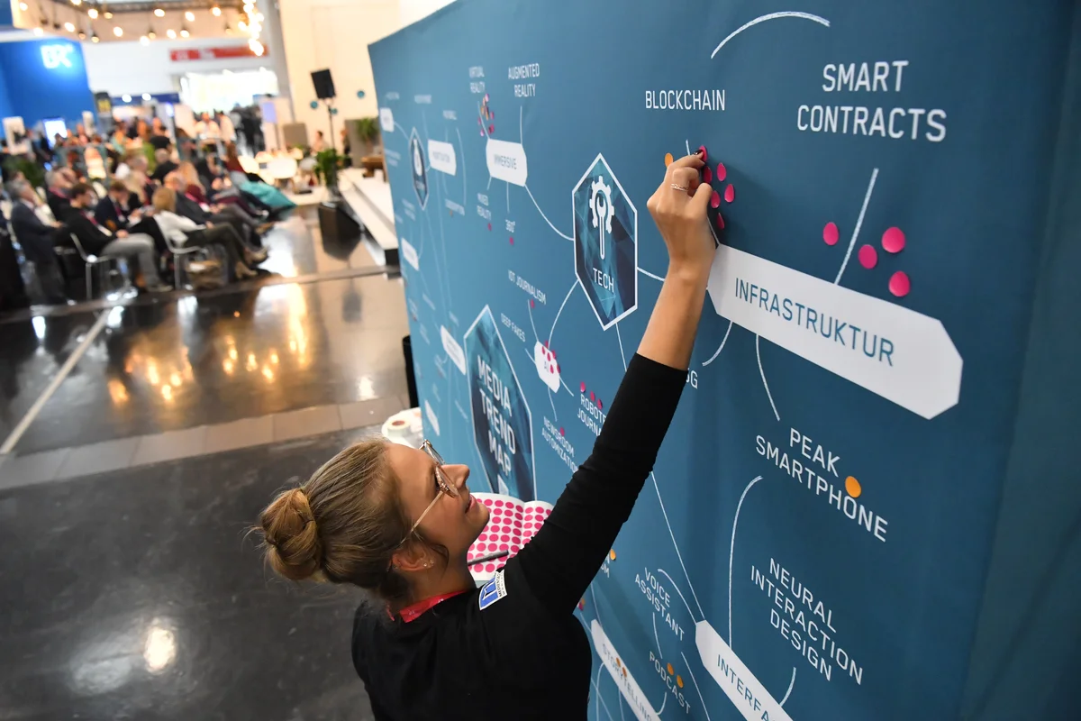 A picture of a woman drawing on a blackboard that has a mind map on it