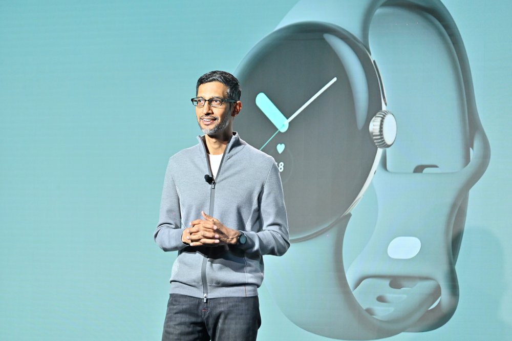 Sundar stands on stage in front of a screen with a photo of the new Pixel watch