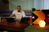 Jesus working at a desk wearing a "Google ITRP" shirt. A light and large pacman made of legos are next to him.