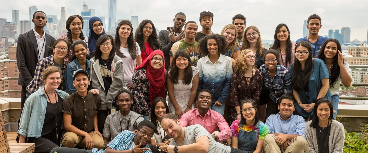 Group of students and Googlers posing together on a rooftop.