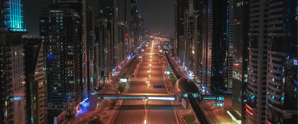Image shows a futuristic city all lit up at night.