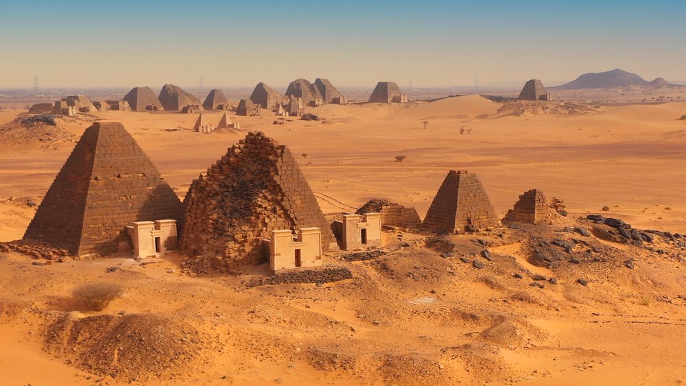 أهرامات على شكل مثلث وخلفها صحراء