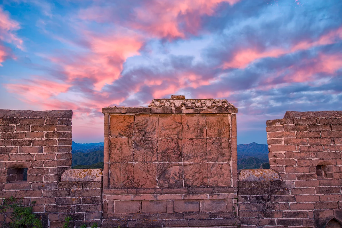 A section of the great wall with a Kirin motif, showing a mythical Chinese creature, against a backdrop of pink and blue clouds.