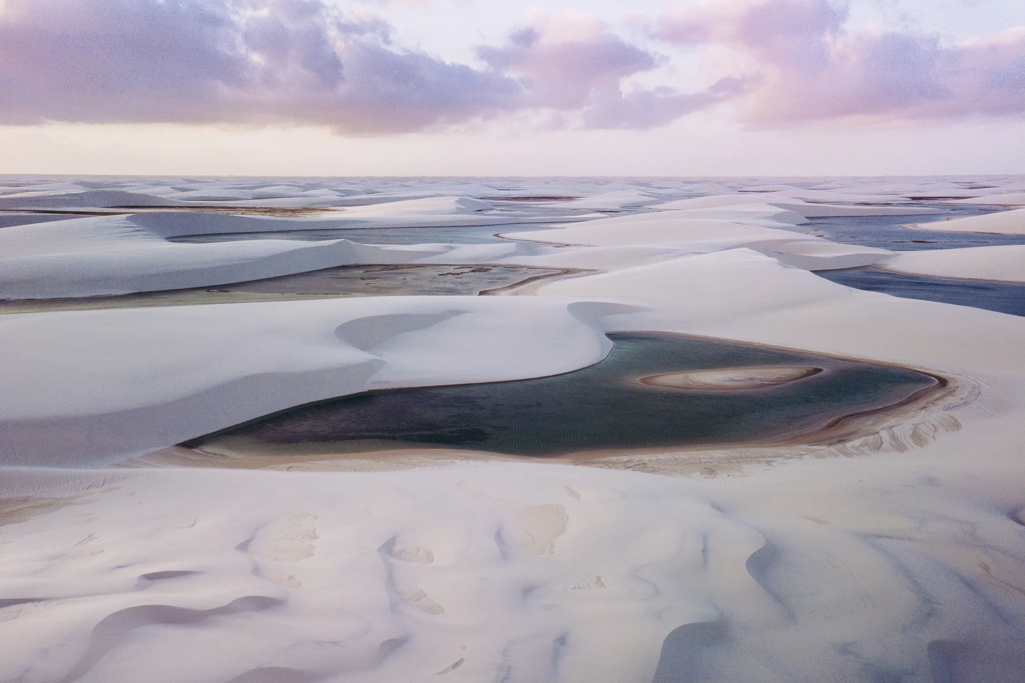 Aerial view of white sand dunes and valleys of fresh water lagoons.