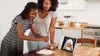 Photo of two people in a kitchen using a recipe on a Google Home to cook