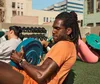 Homme en t-short orange faisant de l'exercice avec le nouveau Fitbit