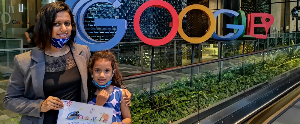 Chai poses with her daughter in front of the Google logo outside of our Singapore office. They are holding up a drawing of the Google logo.